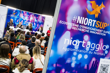 Intervenants en tribune face au public lors du salon de l'enseignement supérieur à l'Acclameur, signalétique Niort Agglo #NiortSup' visible au premier plan
