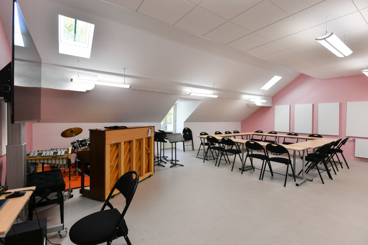 Novembre 2019 Salle de cours équipée d'un piano, d'une batterie et d'un marimba, avec tables disposées en U