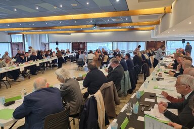 Grande salle rassemblant les élus assis autour de longues tables parallèles lors de la séance d'installation du conseil communautaire