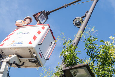 Technicien en nacelle élévatrice réalisant une intervention de maintenance sur un poteau d'éclairage public